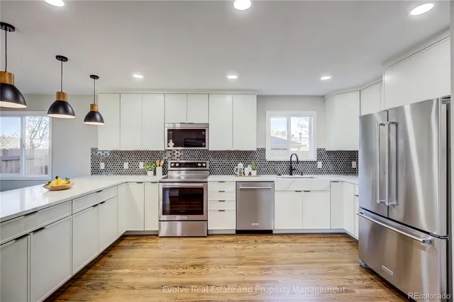 a kitchen with stainless steel appliances granite countertop a refrigerator sink and stove