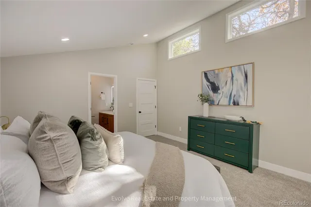 a bedroom with a bed and painting on the wall