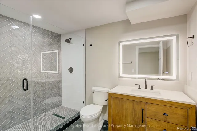 a bathroom with a granite countertop sink toilet and shower