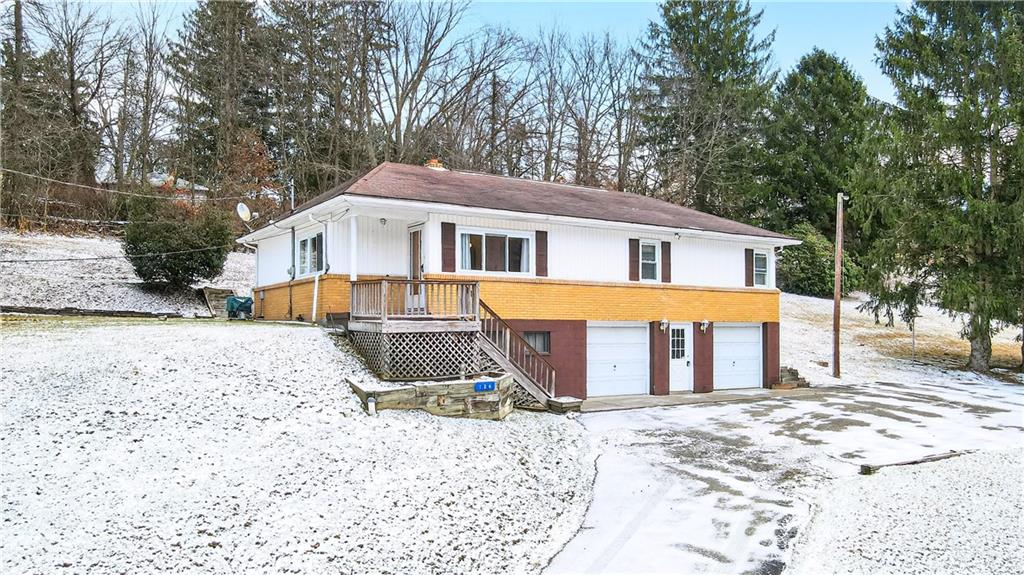 a front view of a house with a yard covered in snow