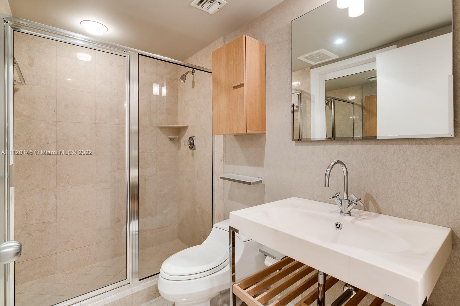 848 Brickell Key Drive, Unit 4002 Miami, FL 33131 - Photo 17 of 19 a bathroom with a sink toilet and shower