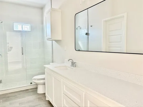 a bathroom with a sink a toilet and shower