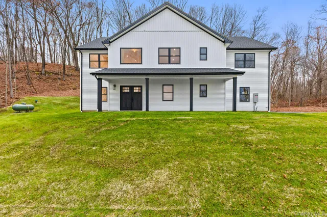 a front view of a house with yard and trees