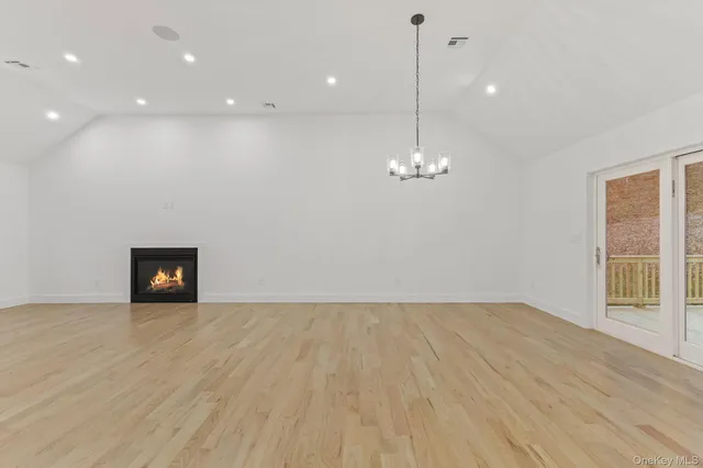 a view of a room with wooden floor and chandelier