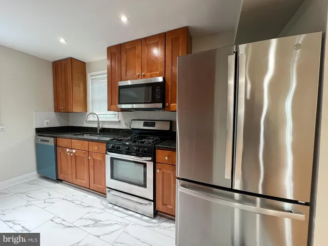 a kitchen with stainless steel appliances granite countertop a refrigerator stove and microwave