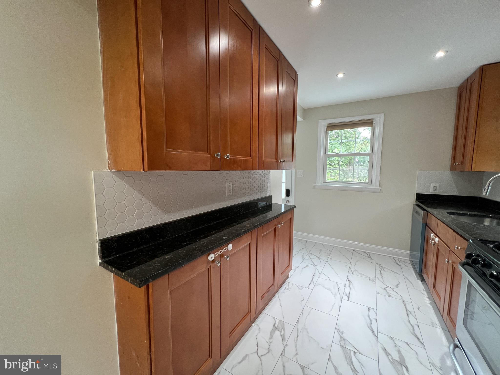 2515 Randolph Road Silver Spring, MD 20902 - Photo 14 of 36 a kitchen with granite countertop stainless steel appliances a sink stove and cabinets
