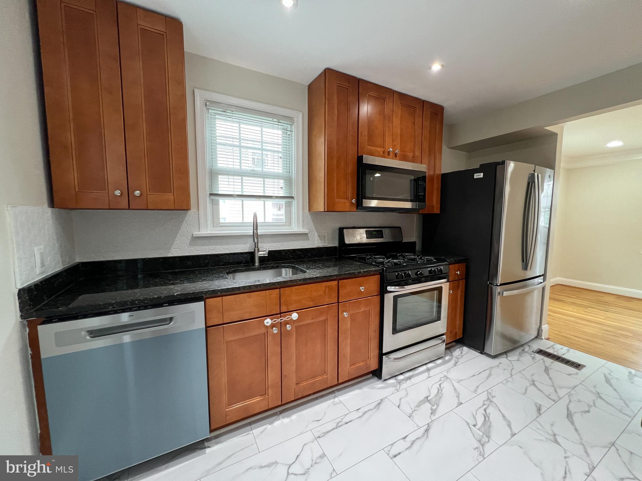 2515 Randolph Road Silver Spring, MD 20902 - Photo 15 of 36 a kitchen with stainless steel appliances granite countertop a stove a sink and a refrigerator