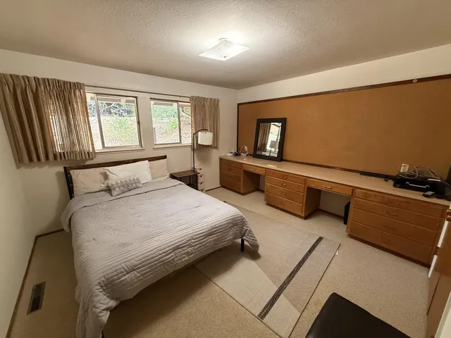 a bedroom with bed couch and window