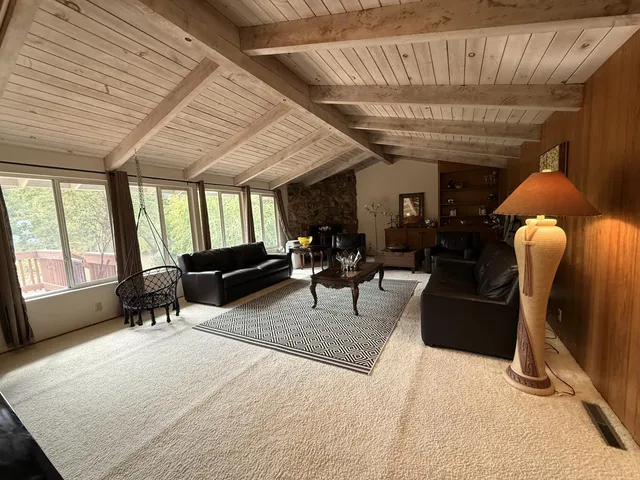 a living room with furniture a flat screen tv and a large window