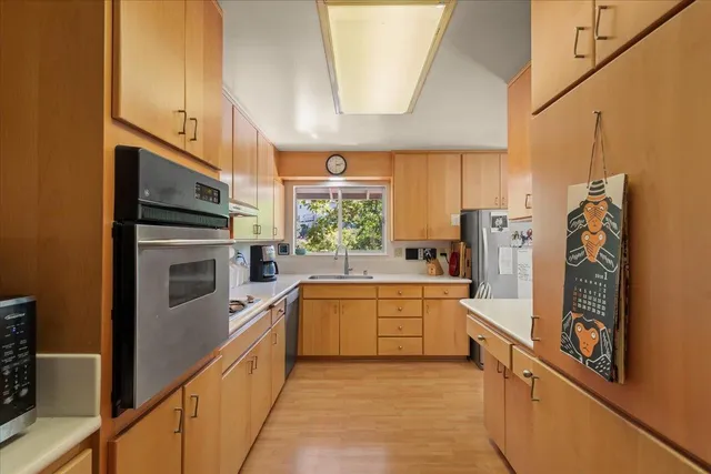 a kitchen with stainless steel appliances a refrigerator sink and cabinets