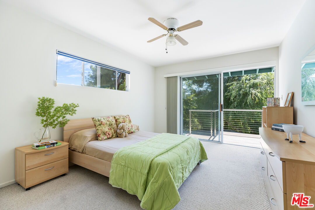 2860 Roscomare Road Los Angeles, CA 90077 - Photo 12 of 15 a bedroom with a balcony a bed and a couch