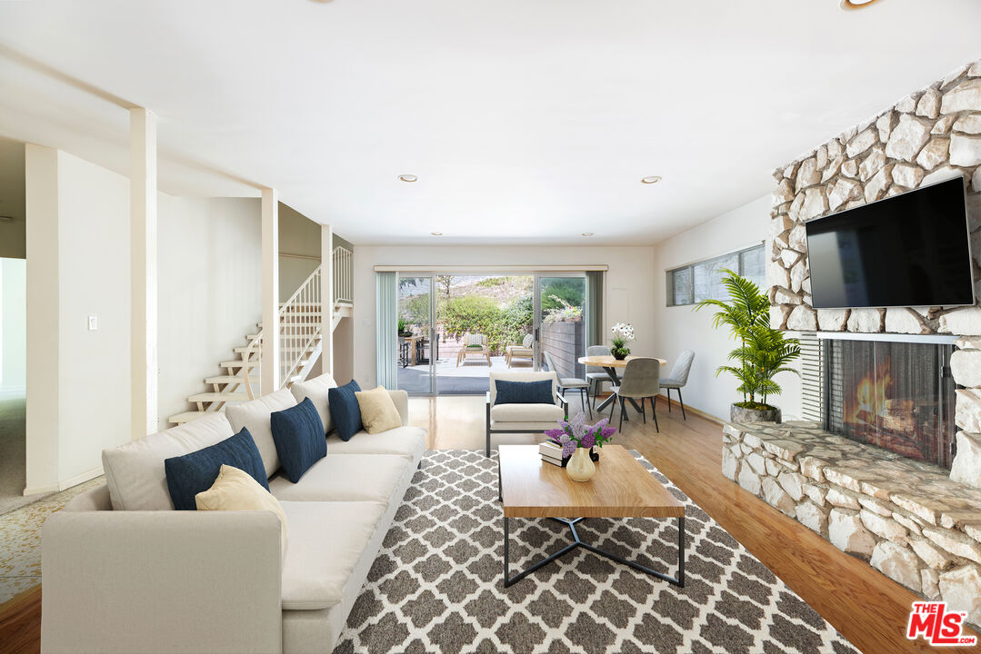 2860 Roscomare Road Los Angeles, CA 90077 - Photo 3 of 15 a living room with furniture a flat screen tv and a large window