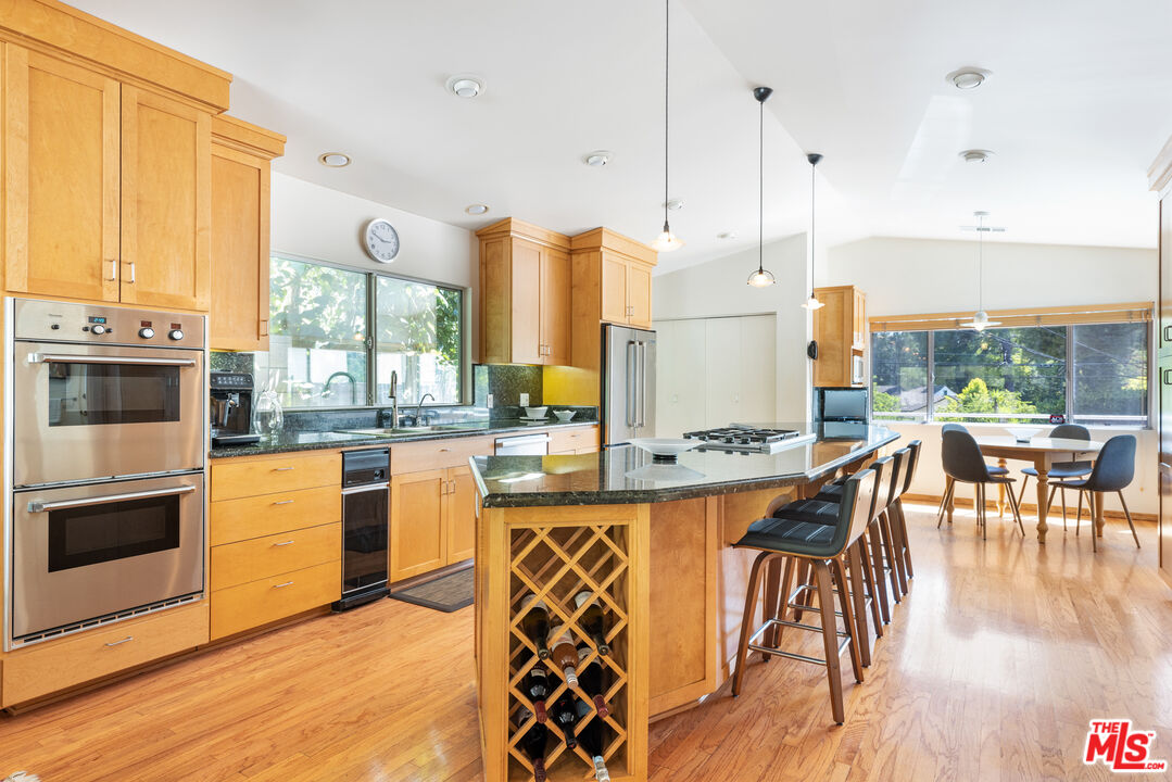2860 Roscomare Road Los Angeles, CA 90077 - Photo 4 of 15 a kitchen with stainless steel appliances granite countertop a stove and cabinets with wooden floor