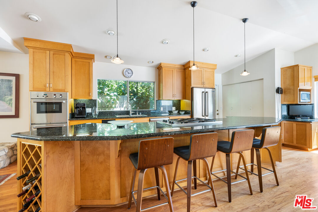 2860 Roscomare Road Los Angeles, CA 90077 - Photo 5 of 15 a kitchen with stainless steel appliances granite countertop a stove a sink and a refrigerator