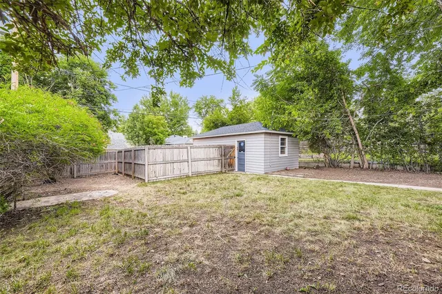 a house is sitting in middle of the green field