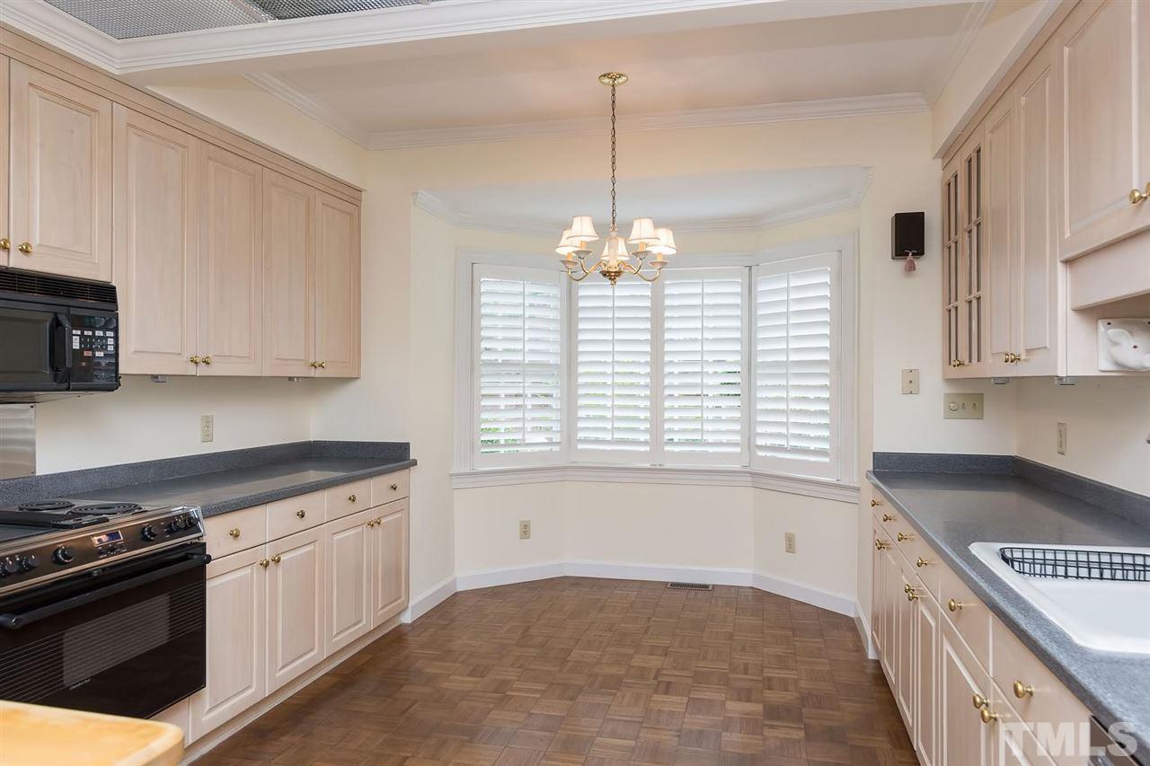 4012 John S Raboteau Wynd Raleigh, NC 27612 - Photo 9 of 25 a kitchen with a stove and a white cabinets