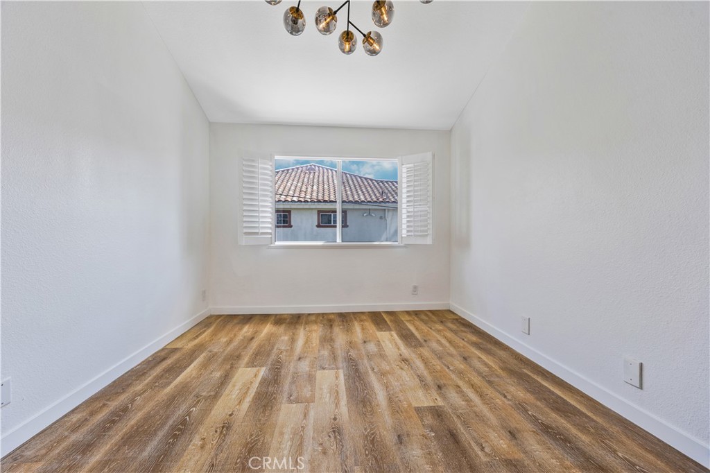 1126 West 228th Street, Unit 16 Torrance, CA 90502 - Photo 21 of 32 a view of an empty room with wooden floor and a window