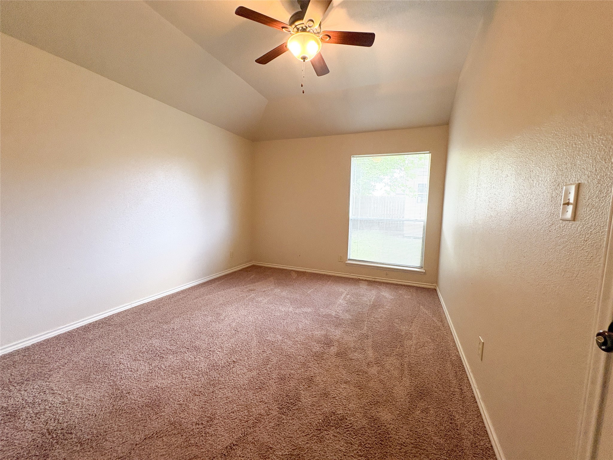 4503 Rattan Avenue Bay City, TX 77414 - Photo 9 of 14 Spacious bedroom with plush carpeting, a ceiling fan, and a large window offering plenty of natural light.