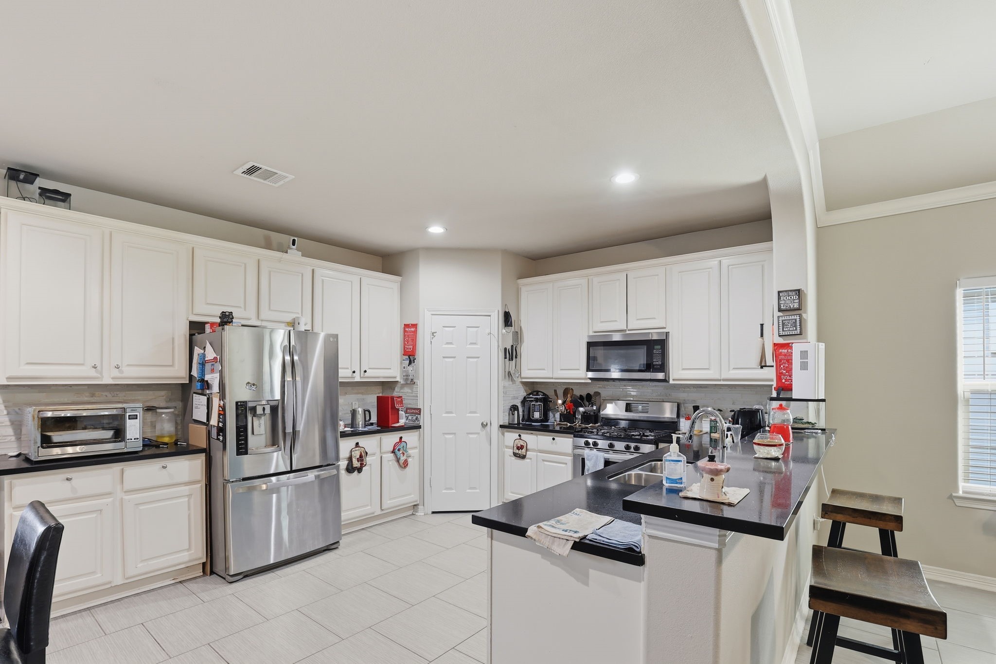 7243 Foxtail Meadow Humble, TX 77338 - Photo 5 of 13 a kitchen with stainless steel appliances a stove a sink a refrigerator a microwave and cabinets