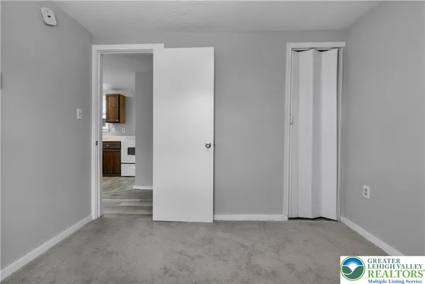 an empty room with closet and mirror