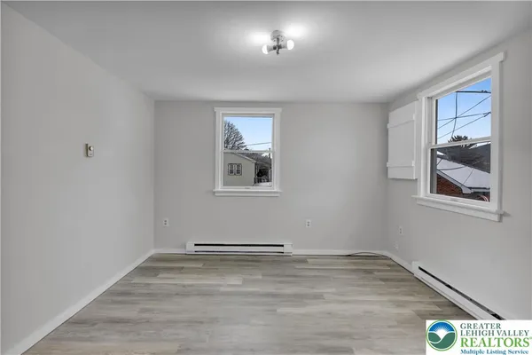 a view of a room with wooden floor and window