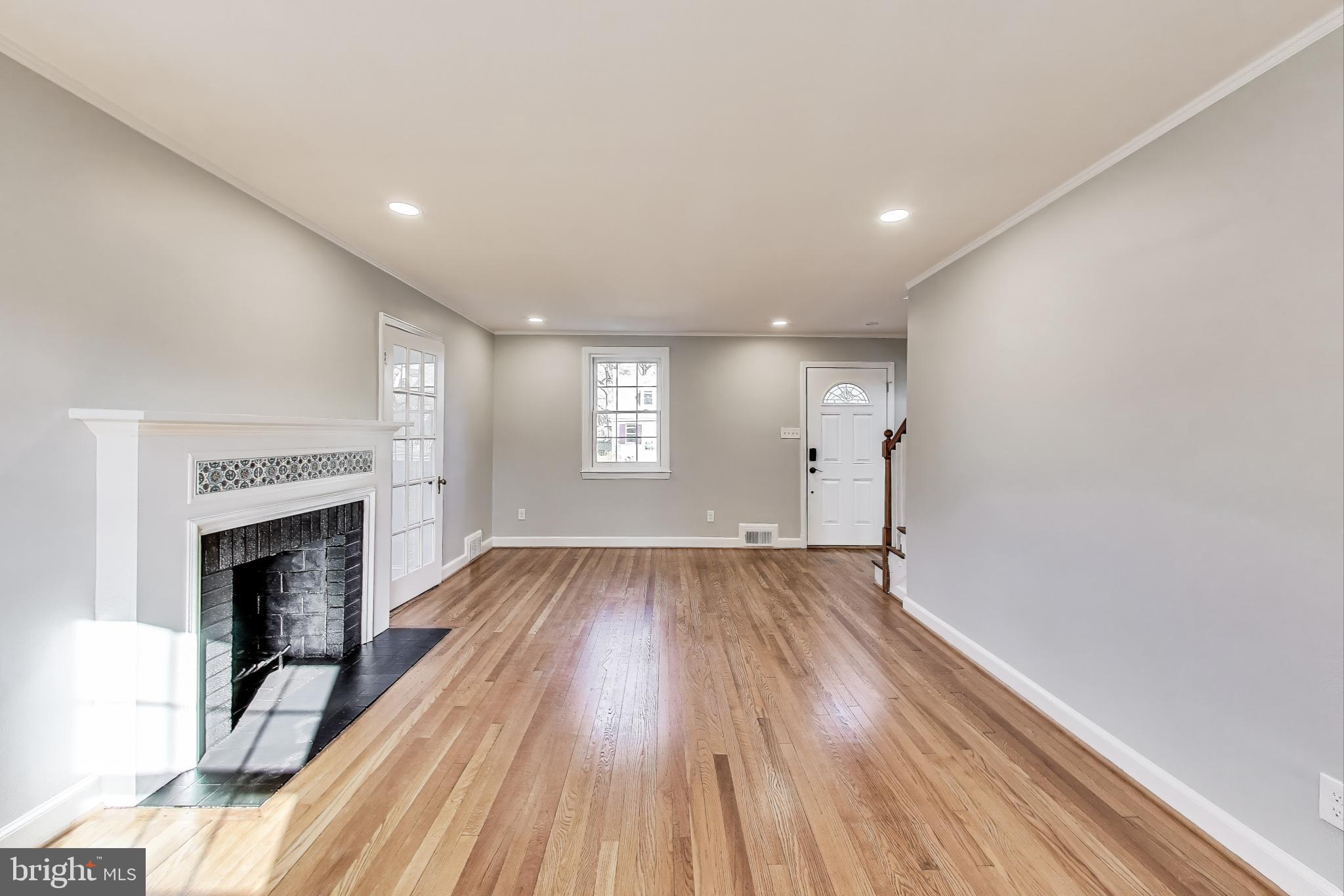 9312 Walden Road Silver Spring, MD 20901 - Photo 8 of 41 a view of empty room with wooden floor and fireplace