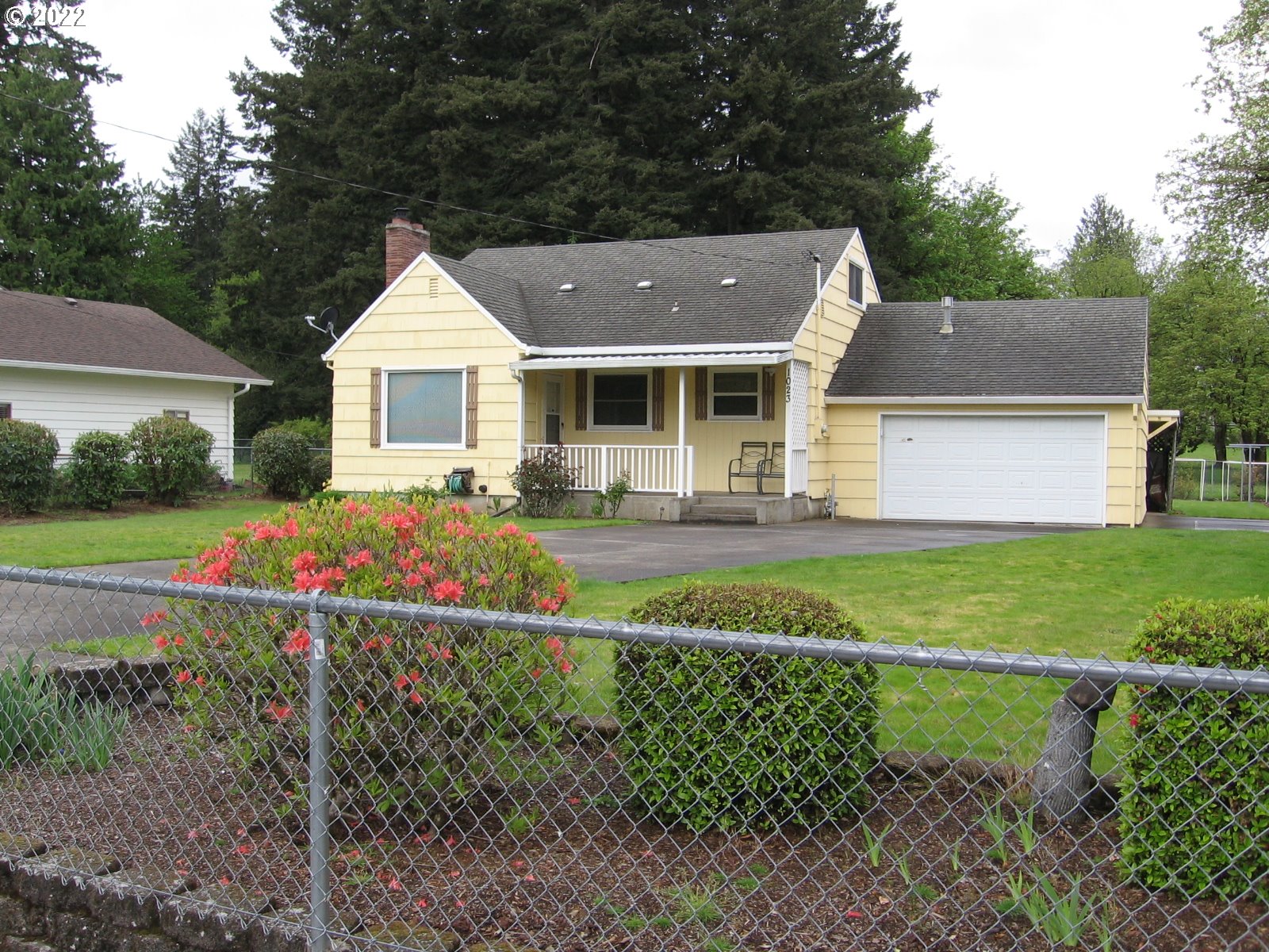 a front view of a house with a yard and potted plants