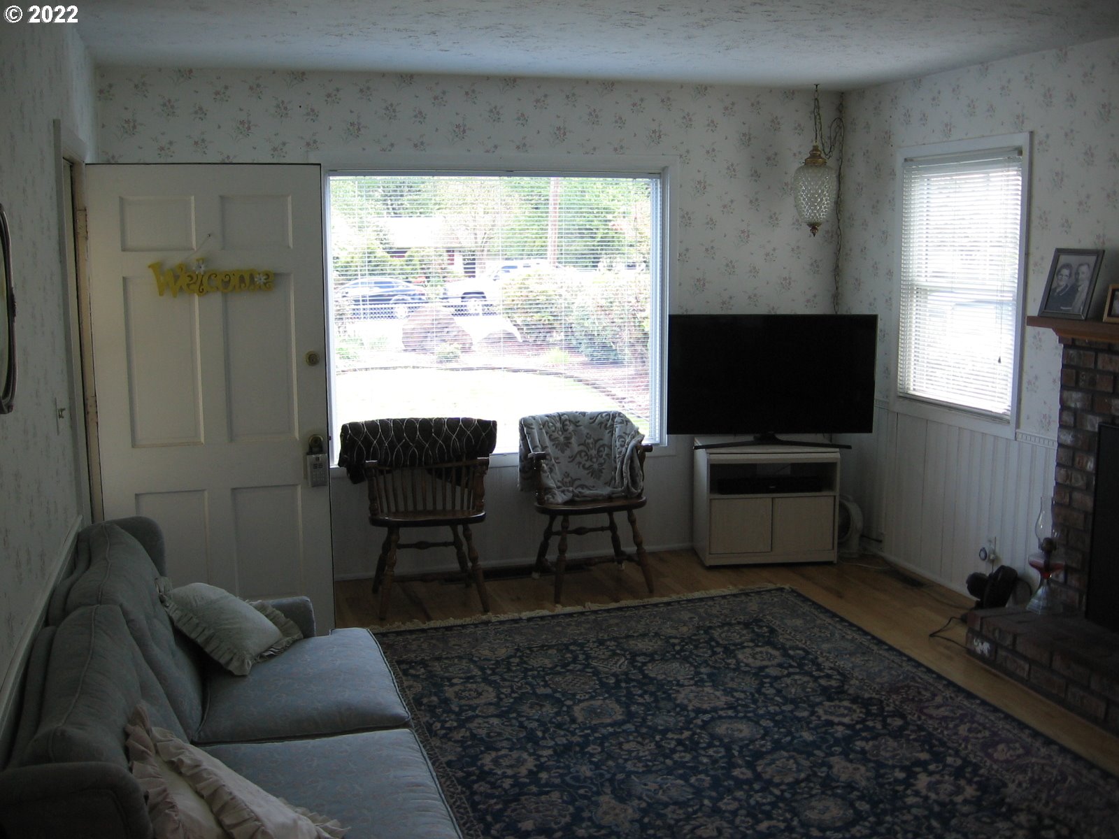 1023 Northeast 172nd Avenue Portland, OR 97230 - Photo 3 of 23 a living room with furniture a flat screen tv and a floor to ceiling window