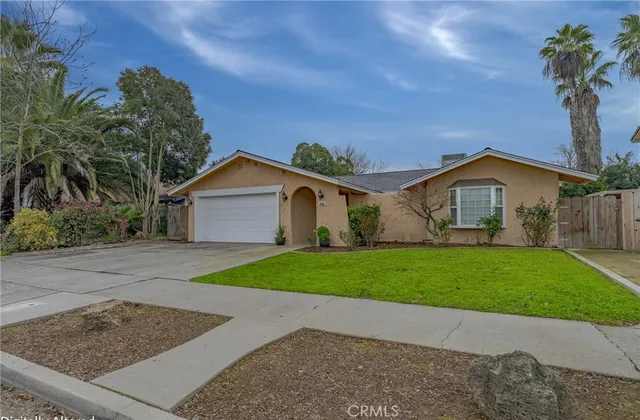 a view of a house with a yard and large tree
