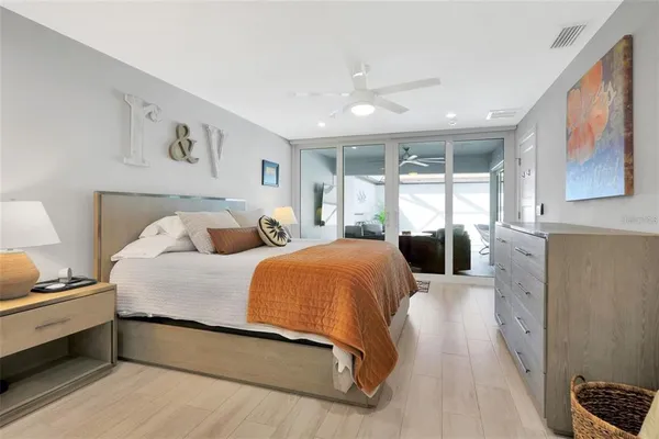 a spacious bedroom with a bed and glass walk in closet