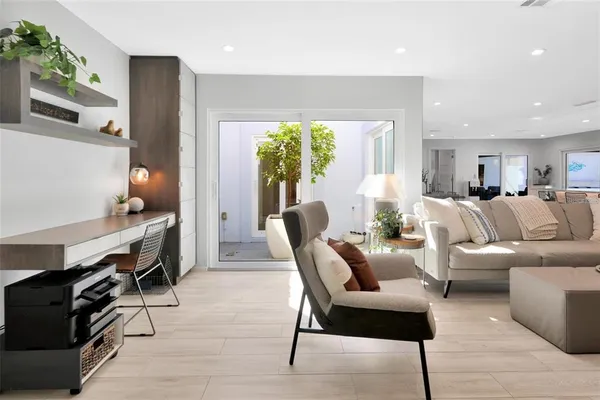 a living room with furniture a window and a potted plant