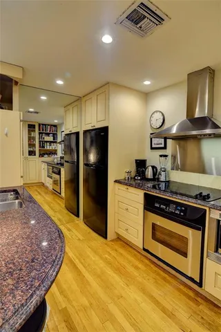a kitchen with stainless steel appliances granite countertop a stove refrigerator and a sink