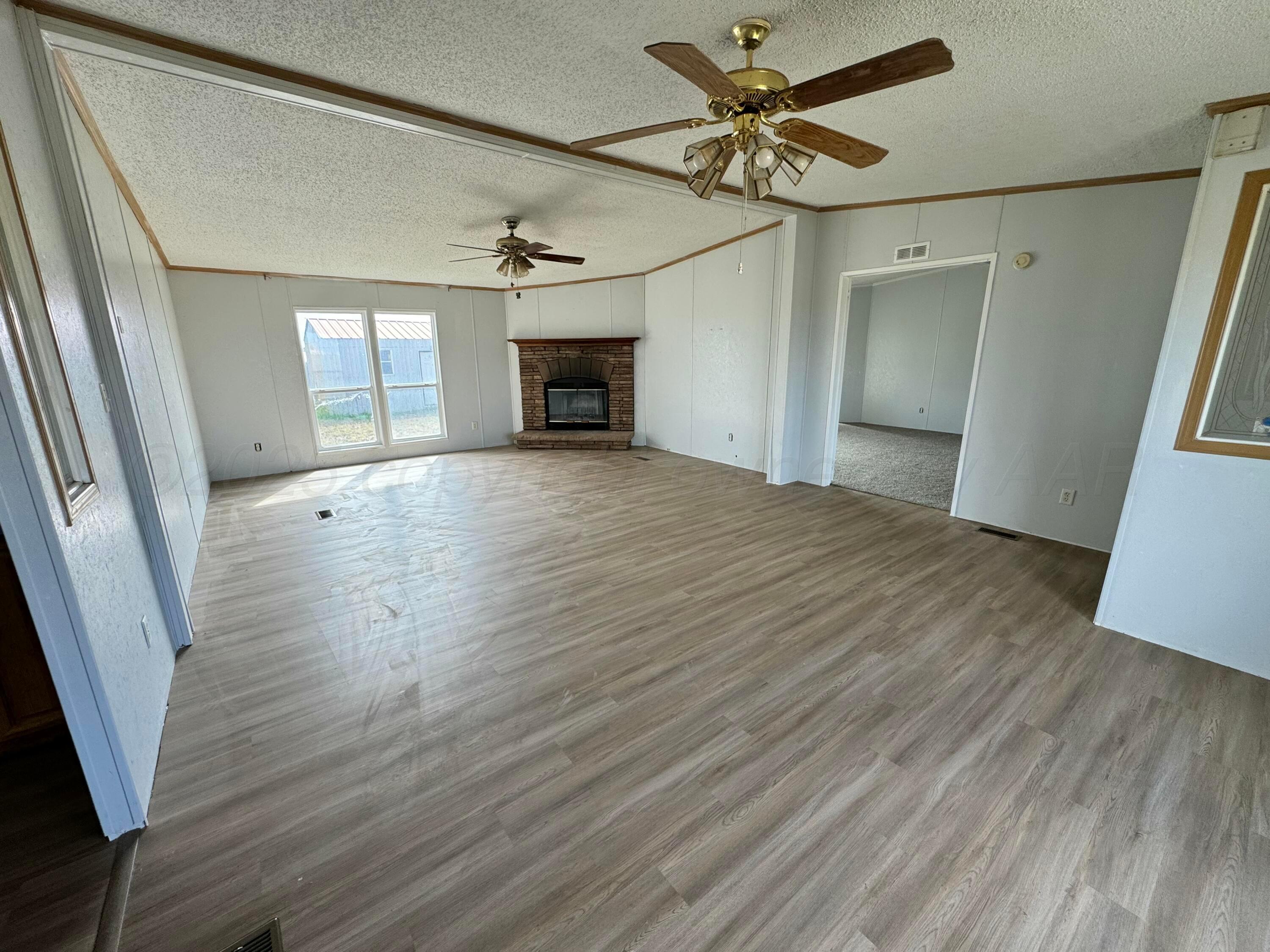1501 Claude Road Amarillo, TX 79118 - Photo 3 of 7 a view of empty room with wooden floor and fan