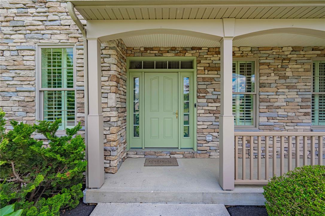 6000 Pond View Terrace Bath, PA 18014 - Photo 11 of 69 A welcoming front entry features a sage green door framed by elegant stone siding and a covered porch.