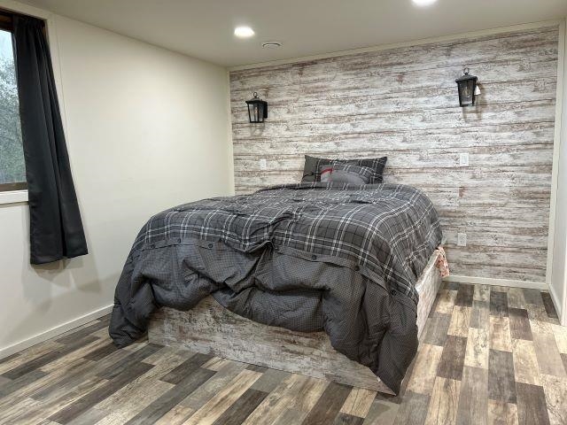 8353 Mannik Road Iron River, WI 54847 - Photo 17 of 48 Bedroom featuring an accent wall, wood finished floors, recessed lighting, and wooden walls