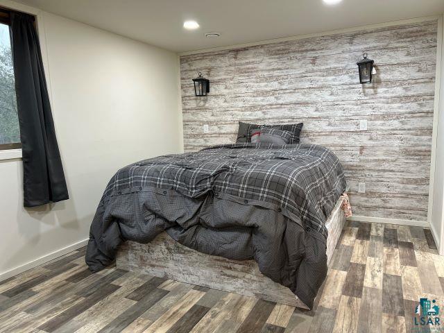 8353 Mannik Road Iron River, WI 54847 - Photo 17 of 48 Bedroom featuring an accent wall, wood finished floors, recessed lighting, and wooden walls