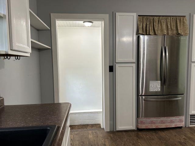 8353 Mannik Road Iron River, WI 54847 - Photo 24 of 48 Kitchen featuring freestanding refrigerator, open shelves, dark wood finished floors, white cabinetry, and dark countertops