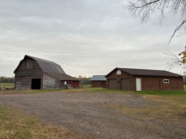 8353 Mannik Road Iron River, WI 54847 - Photo 5 of 48 View of yard with an outdoor structure, a barn, and a garage