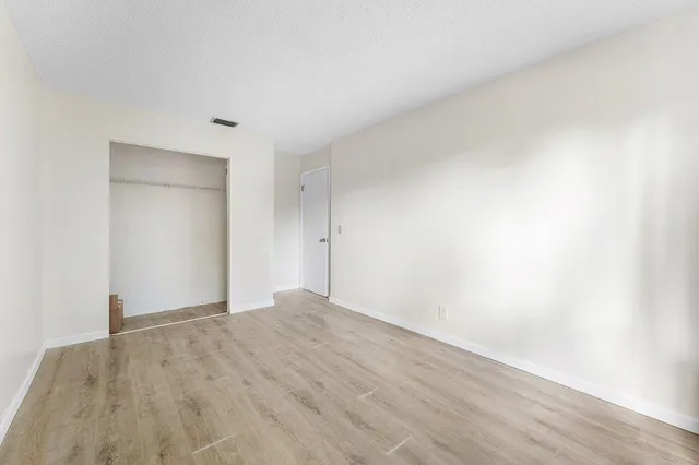 a view of an empty room with wooden floor