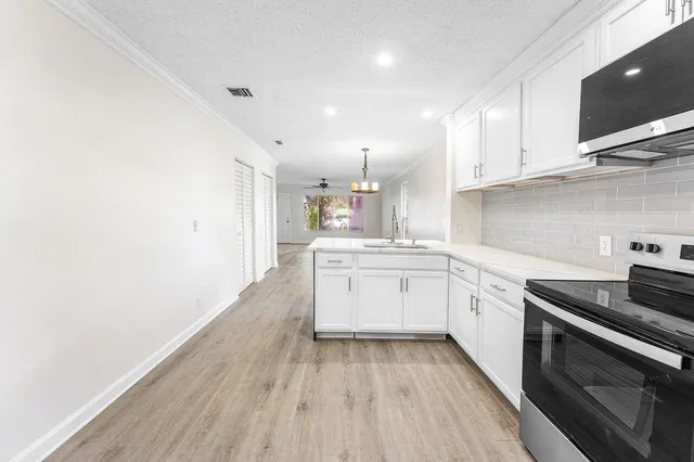 a kitchen with granite countertop white cabinets and white appliances