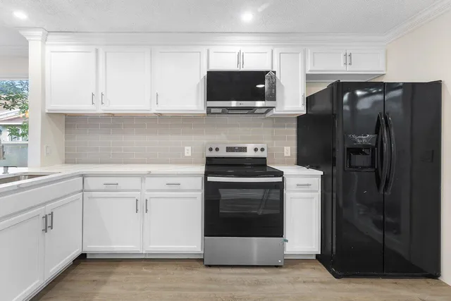 a kitchen with white cabinets and stainless steel appliances