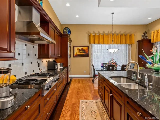 a kitchen with stainless steel appliances a sink stove and wooden cabinets