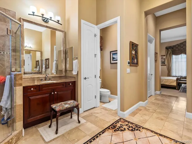 a spacious bathroom with a toilet a sink and a mirror