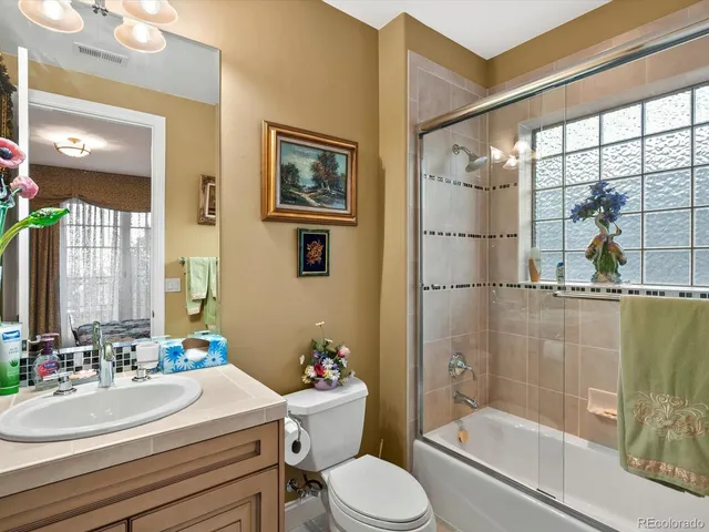 a bathroom with a sink a toilet a mirror and shower