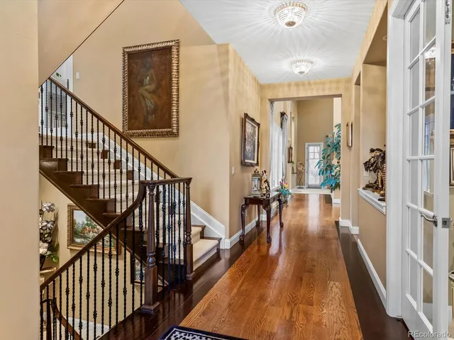 a view of a hallway with wooden floor and stairs