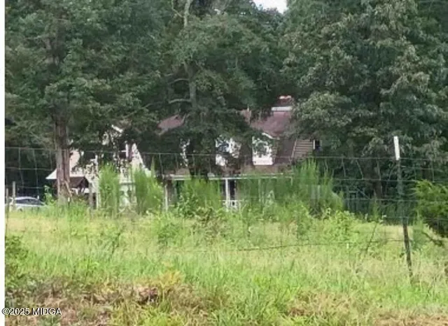 a backyard of a house with lots of green space and lake view
