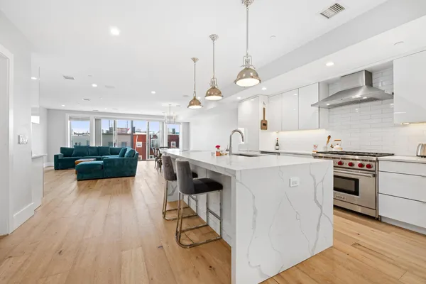 a kitchen with stainless steel appliances kitchen island a stove and a wooden floors