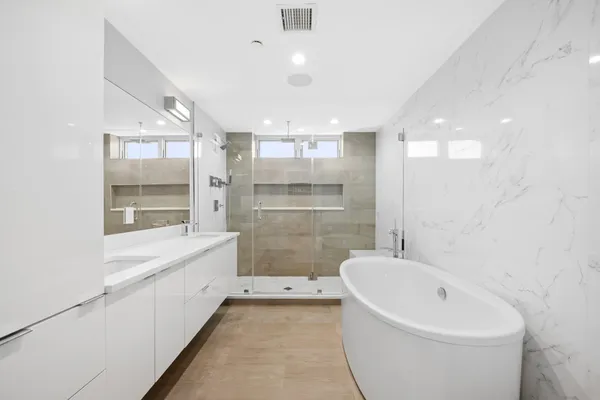 a bathroom with a double vanity sink mirror and shower