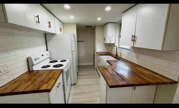 a living room with stainless steel appliances kitchen island granite countertop furniture a rug and a window