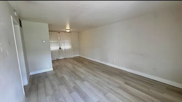 a view of a room with wooden floor and a hallway
